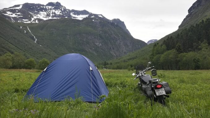 Motorcykel ved siden af iglotelt på en mark